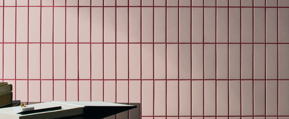 Detailní záběr na minimalistický koupelnový obklad s precizně vyvedenou barevnou spárou v tónu materiálu.