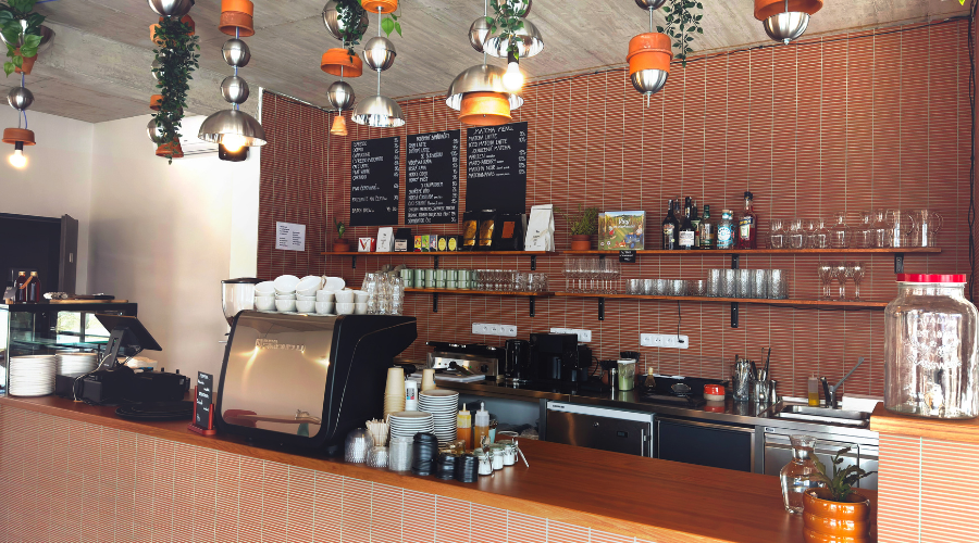 Designový interiér Café & Bistro Terakota v Pasohlávkách s výrazným červeným obkladem Mutina Fringe a historickými keramickými květináči. 