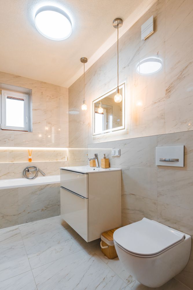 Návrh malé koupelny v jemných tónech: vana s nikou, mramorové obklady a designové topení 5