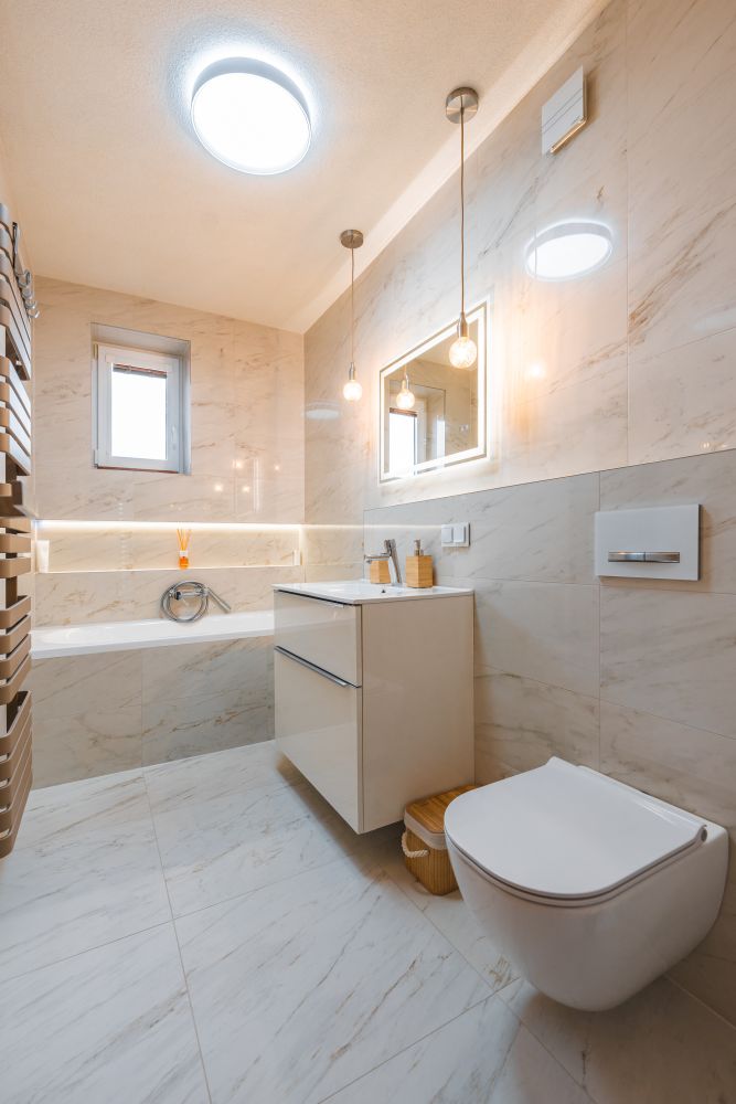 Návrh malé koupelny v jemných tónech: vana s nikou, mramorové obklady a designové topení 10