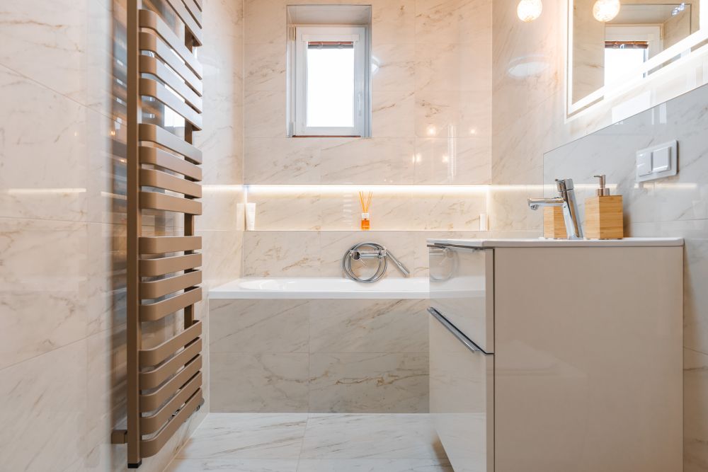 Návrh malé koupelny v jemných tónech: vana s nikou, mramorové obklady a designové topení 12