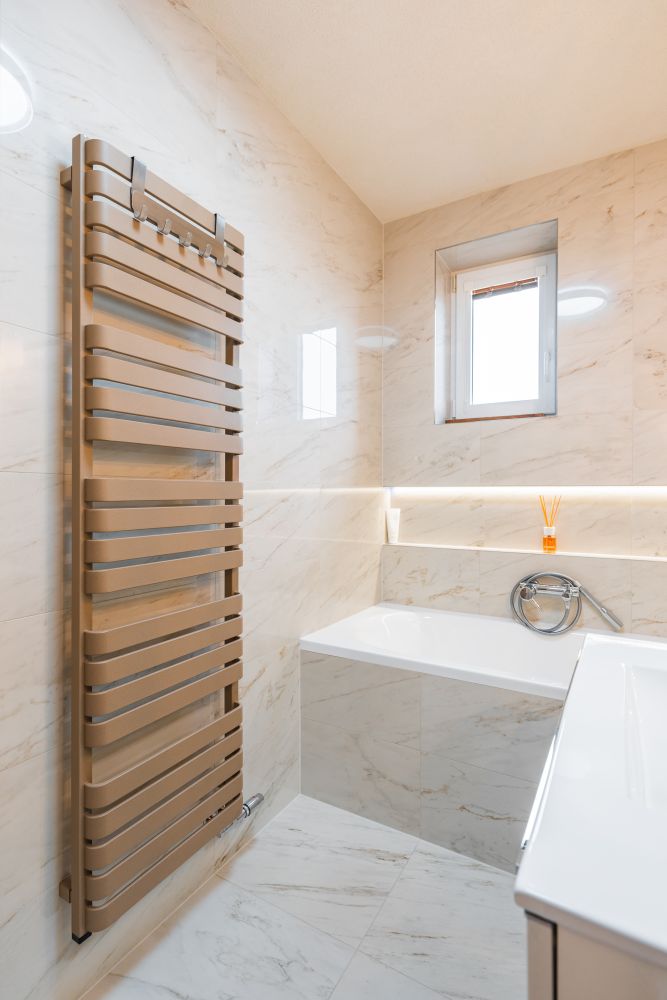 Návrh malé koupelny v jemných tónech: vana s nikou, mramorové obklady a designové topení 21