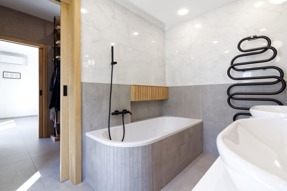 Realizace minimalistické koupelny – velkoformátové obklady a dlažba v dokonalých imitacích, asymetrická vana i sprcha bez vaničky 4